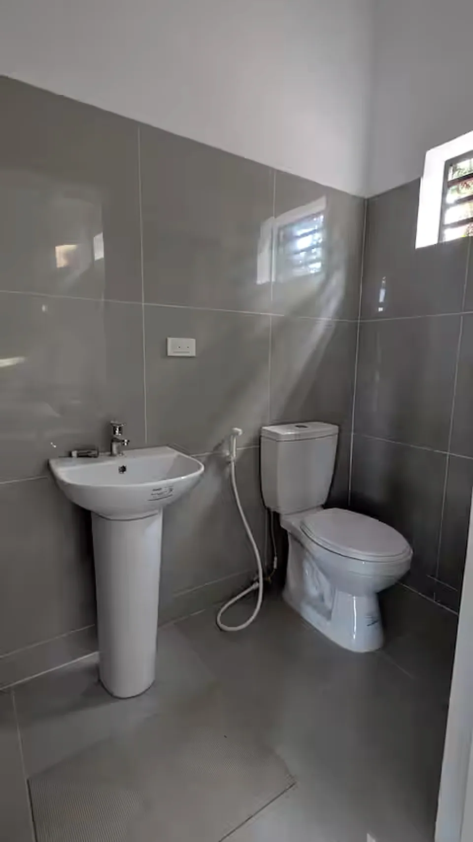 Private tiled bathroom with toilet, bidet, and sink