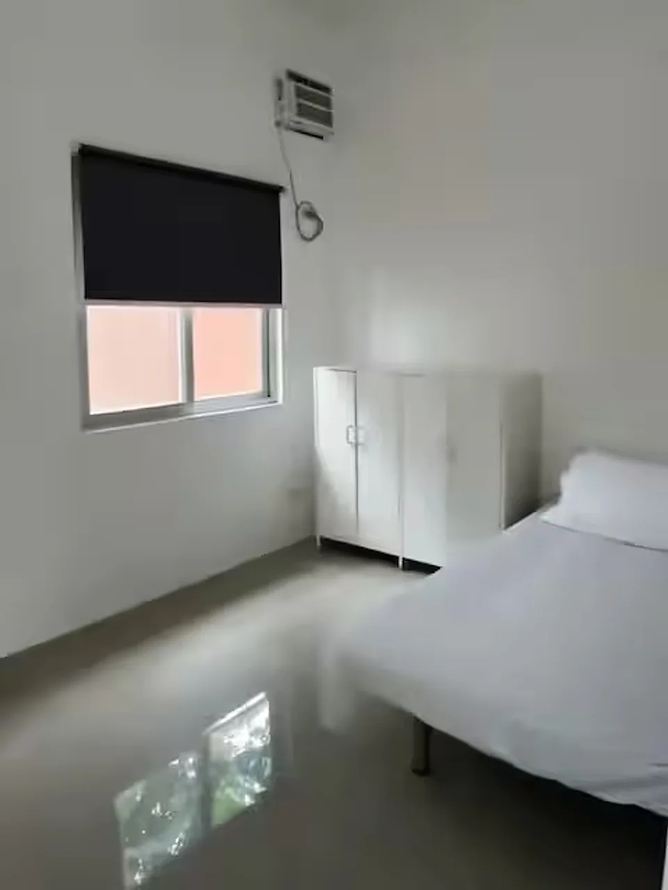 Bright guest house bedroom with a bed and storage cabinet