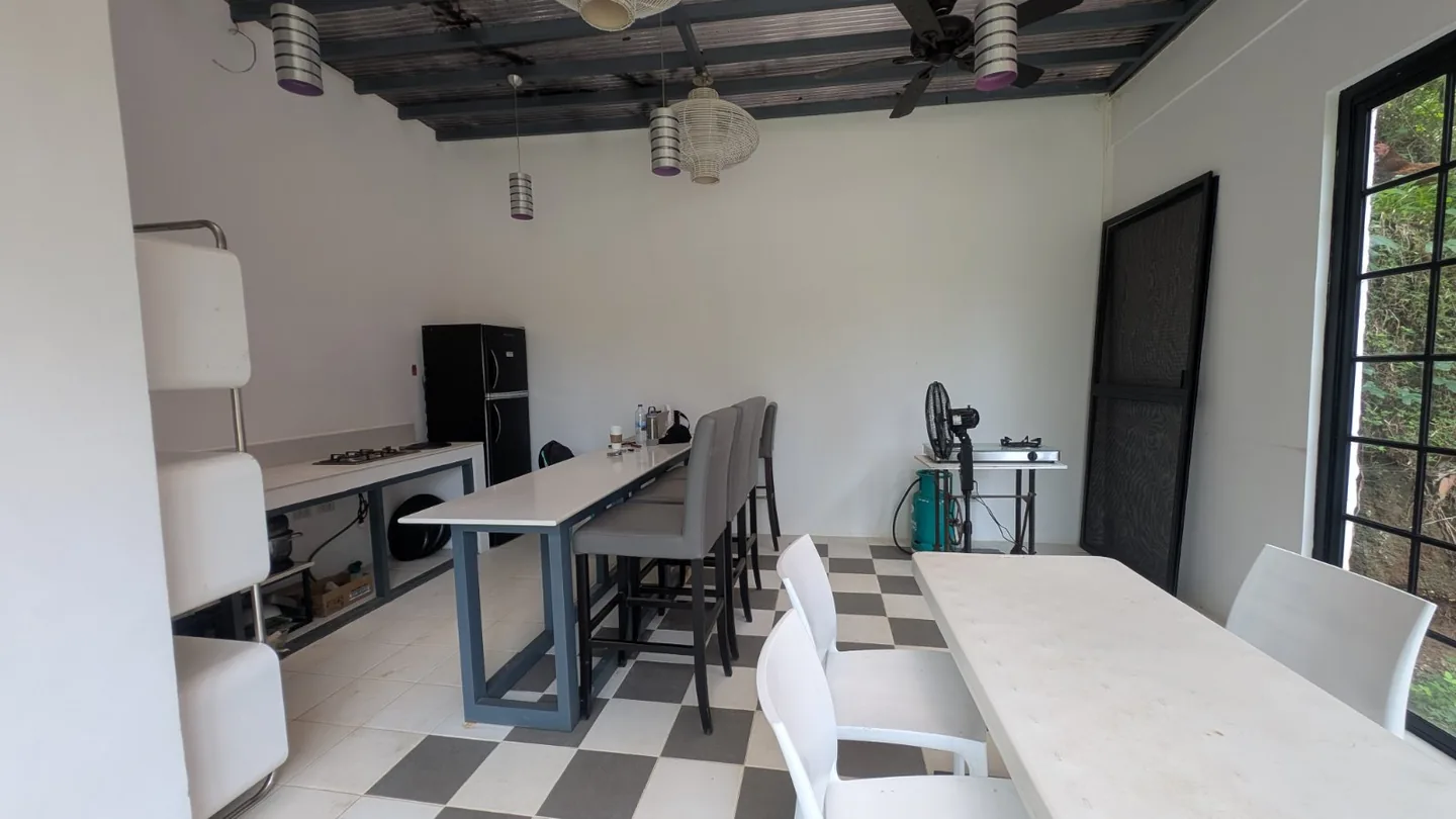 Mess Hall dining tables, counter seating and kitchen with a checkerboard floor