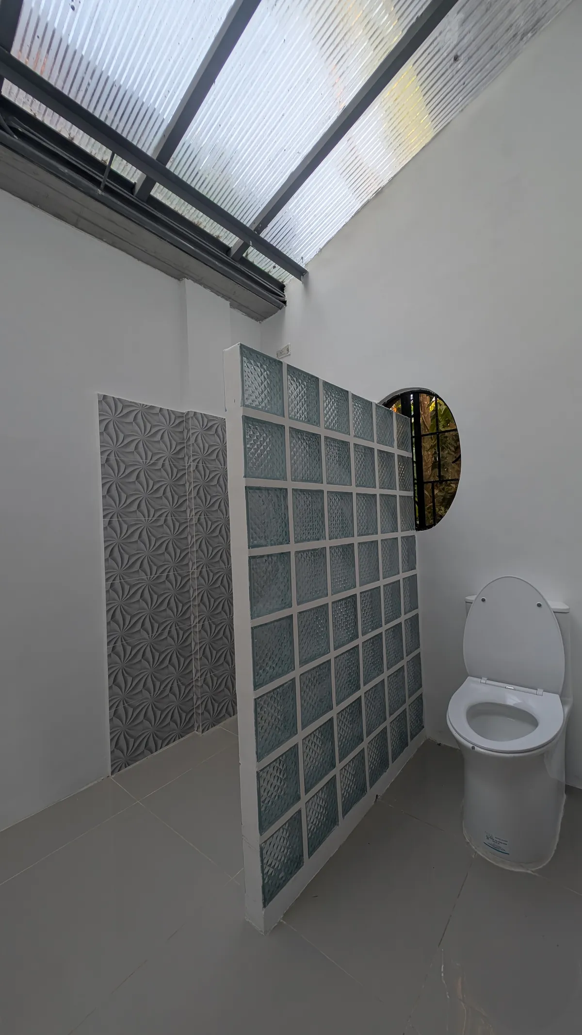 Private bathroom with a glass-block shower partition and toilet