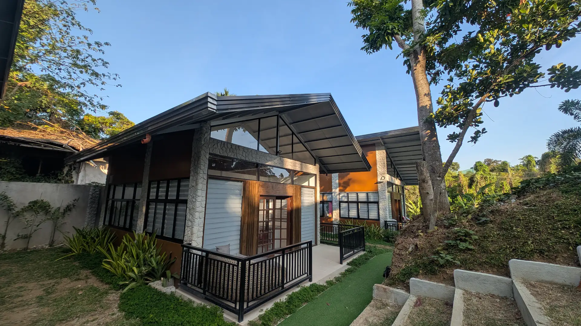 Modern Golden Sunset lodging units with a landscaped pathway and trees