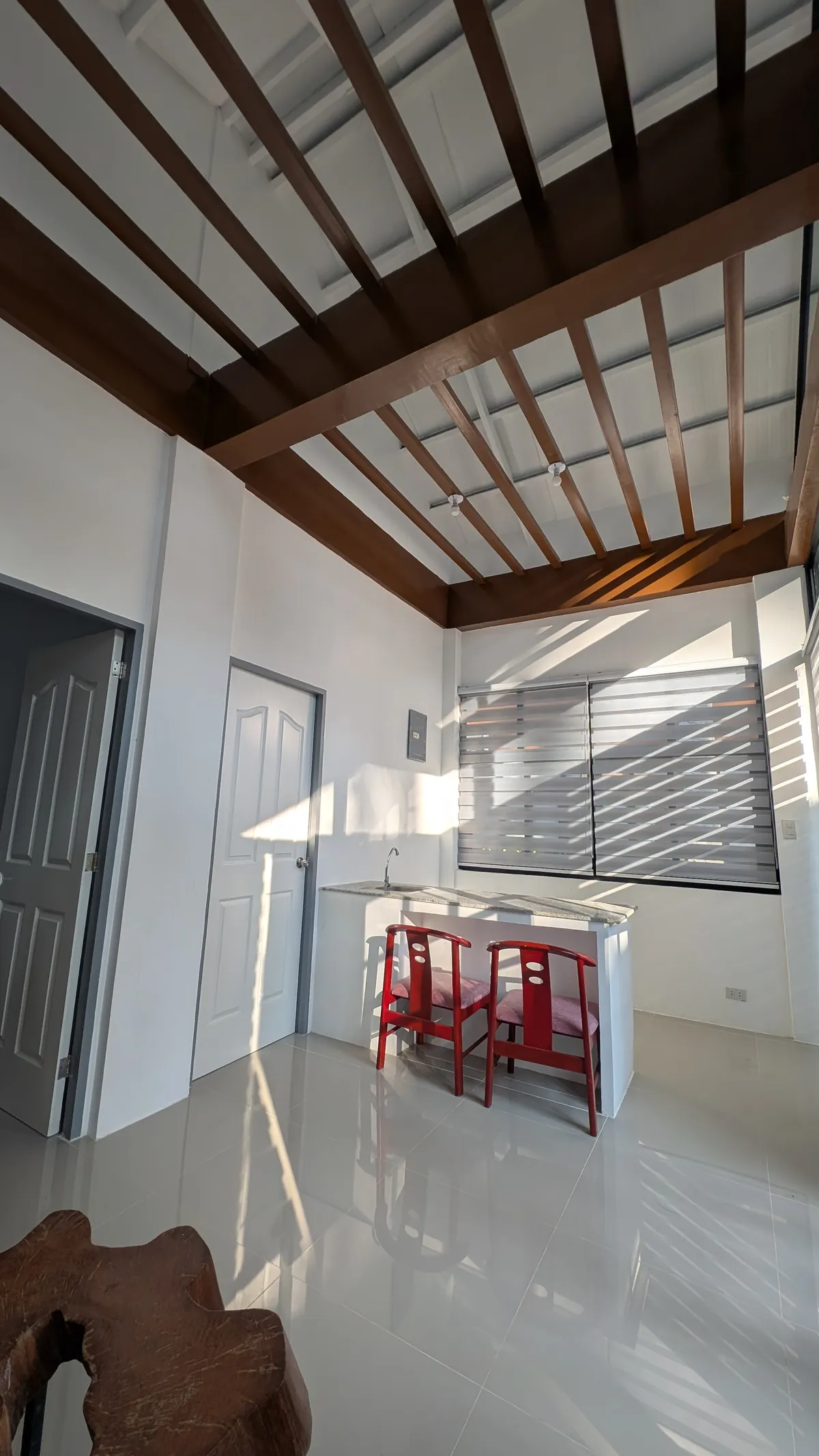 Compact kitchenette with counter seating and warm sunlight